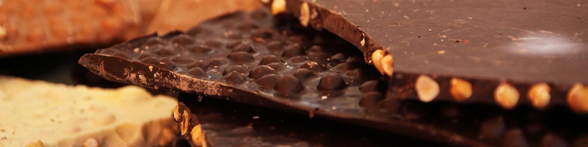 Pieces of pure and white chocolate containing nuts stacked on top of one another