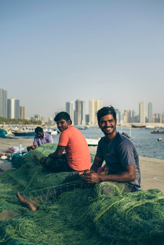 Contented employees mending fishing nets in the United Arab Emirates